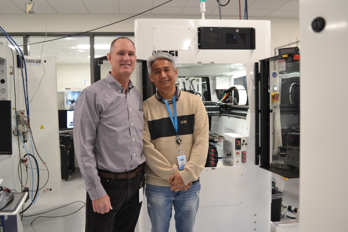 Peter Cronin seen in front of a machine with a male colleague